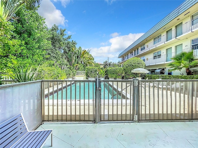 view of gate featuring an outdoor pool and fence
