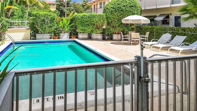 view of pool featuring a pool, a gate, fence, and a patio