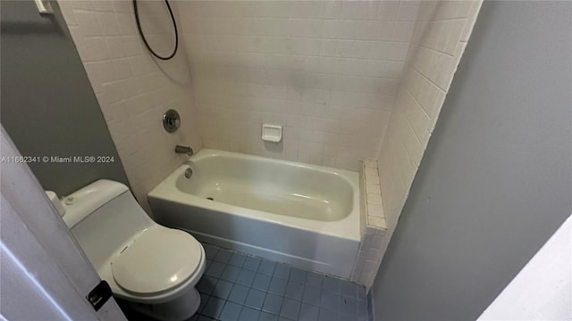 bathroom with toilet, tiled shower / bath, and tile patterned floors