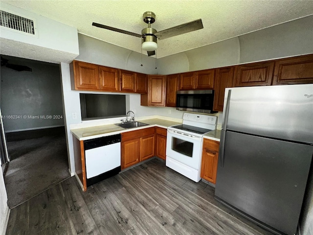 kitchen with appliances with stainless steel finishes, sink, a textured ceiling, dark hardwood / wood-style flooring, and ceiling fan