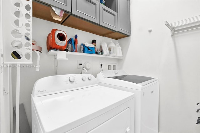 laundry area featuring separate washer and dryer and cabinets