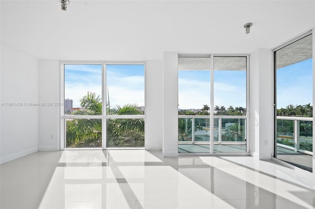 tiled spare room featuring floor to ceiling windows