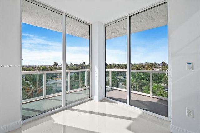 interior space with floor to ceiling windows, light tile patterned floors, and a healthy amount of sunlight