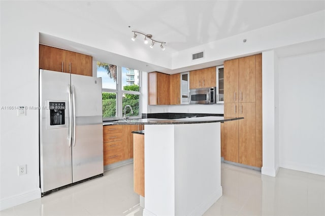 kitchen with a kitchen island, light tile patterned flooring, and stainless steel appliances