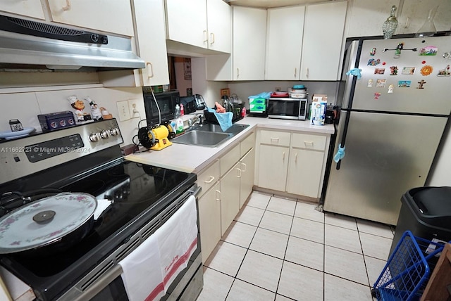 kitchen with stainless steel appliances, white cabinets, light tile patterned floors, and sink