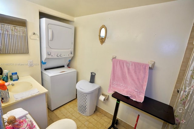 bathroom with vanity, toilet, and stacked washing maching and dryer