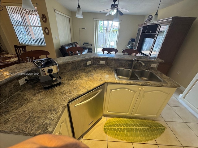 kitchen with dishwasher, sink, hanging light fixtures, light tile patterned floors, and ceiling fan