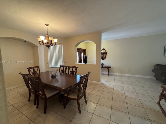 dining room with light tile patterned floors and a notable chandelier