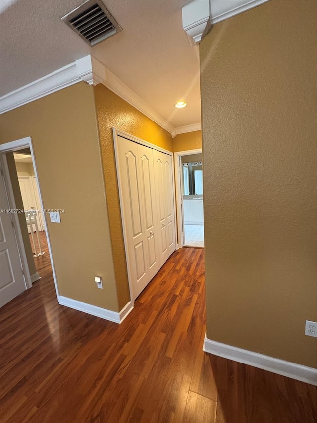 hall with hardwood / wood-style flooring and crown molding