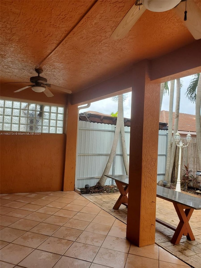 unfurnished sunroom featuring ceiling fan and plenty of natural light