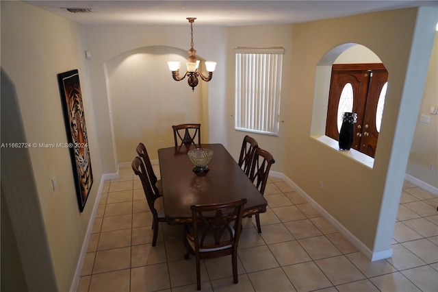 dining space featuring light tile patterned floors and a notable chandelier