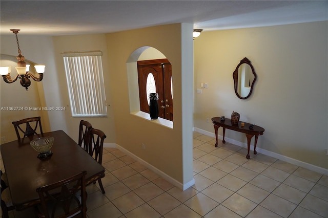 tiled dining area with an inviting chandelier