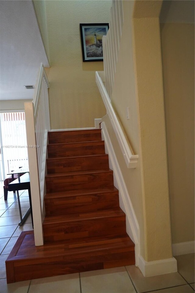 staircase with tile patterned floors