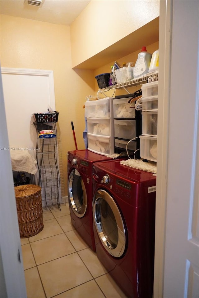 laundry area with light tile patterned floors and washer and clothes dryer