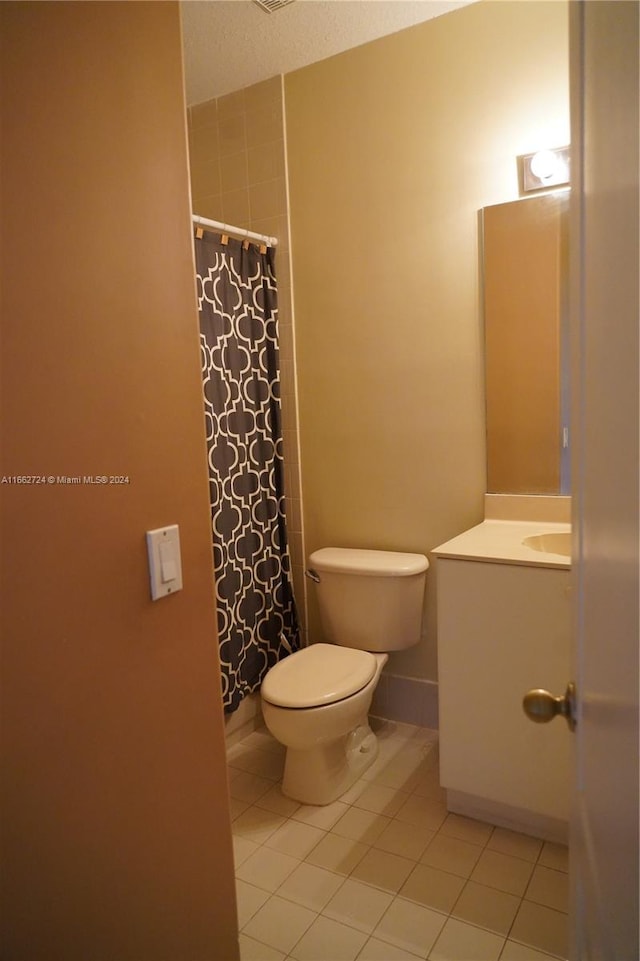 bathroom featuring vanity, toilet, a textured ceiling, a shower with curtain, and tile patterned flooring