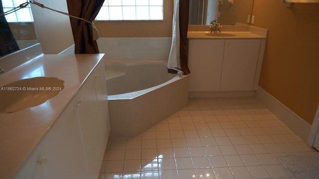 bathroom with tile patterned floors, a bath, and vanity