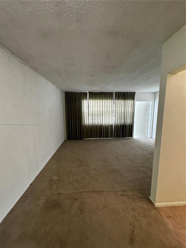 empty room featuring a textured ceiling and carpet floors