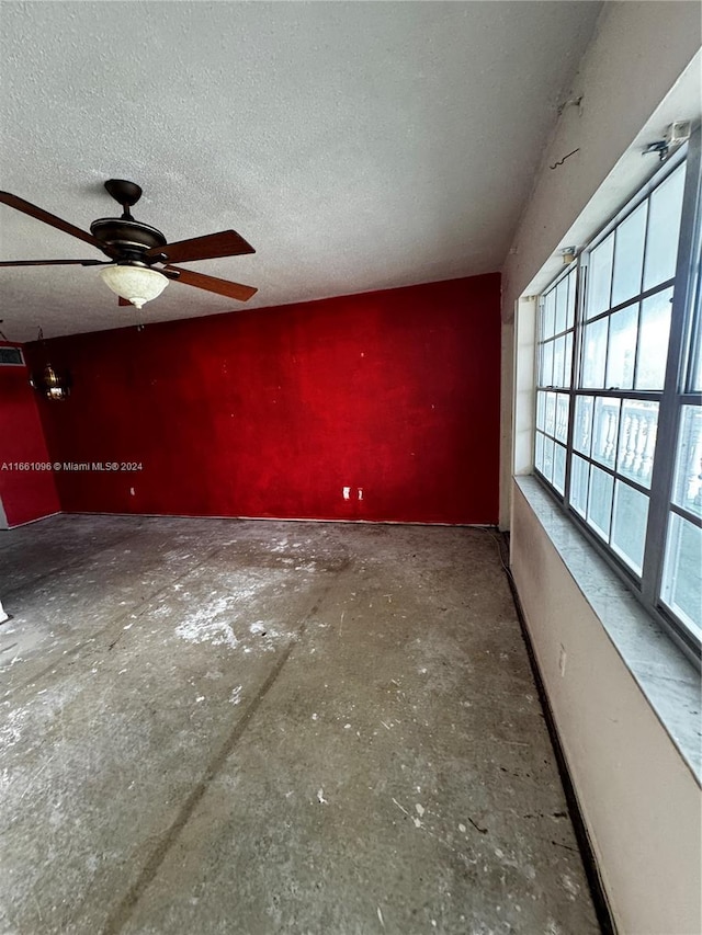 spare room featuring ceiling fan, a textured ceiling, and concrete floors