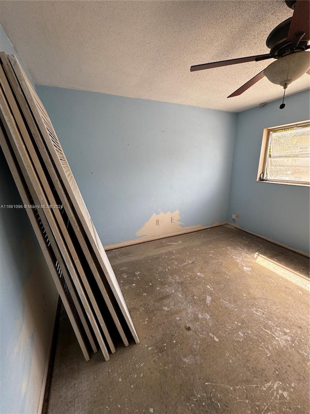 empty room featuring ceiling fan and a textured ceiling