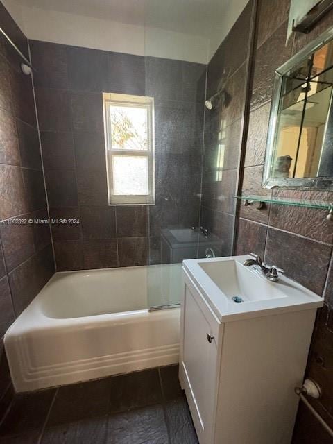 bathroom featuring tile walls, vanity, tile patterned floors, and tiled shower / bath