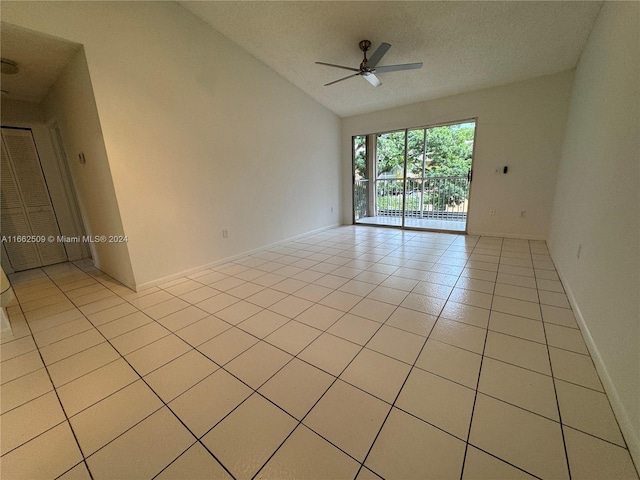 empty room with light tile patterned floors, a textured ceiling, ceiling fan, and lofted ceiling