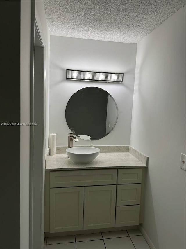 bathroom with tile patterned flooring, vanity, and a textured ceiling