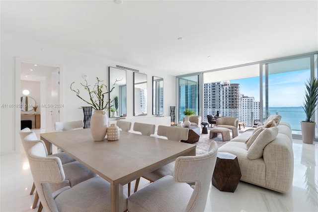 dining room featuring a water view and a wall of windows