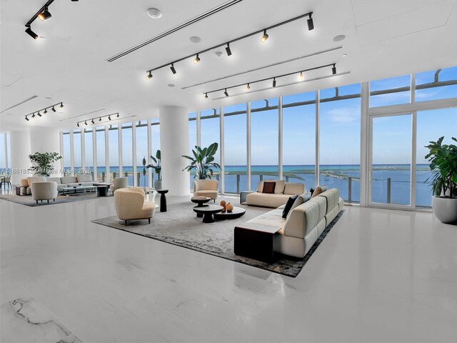 dining room featuring light wood-type flooring, floor to ceiling windows, and a water view