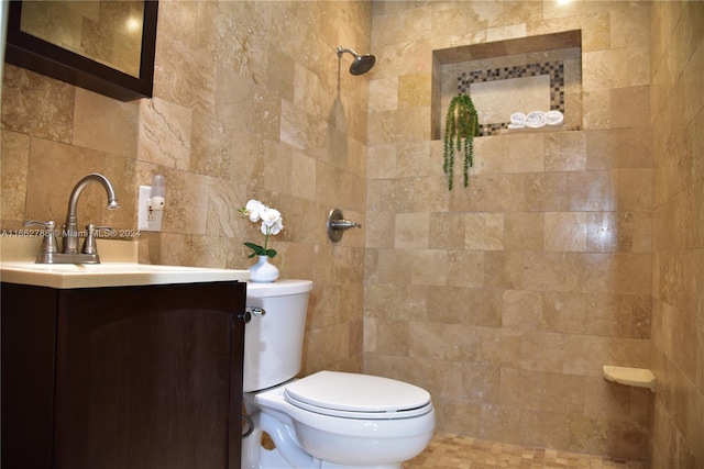 bathroom featuring tile walls, vanity, toilet, and tiled shower