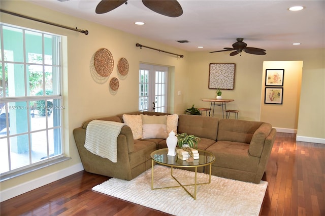 living room featuring a wealth of natural light, ceiling fan, and dark hardwood / wood-style flooring