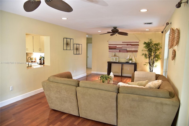 living room featuring ceiling fan and dark hardwood / wood-style floors