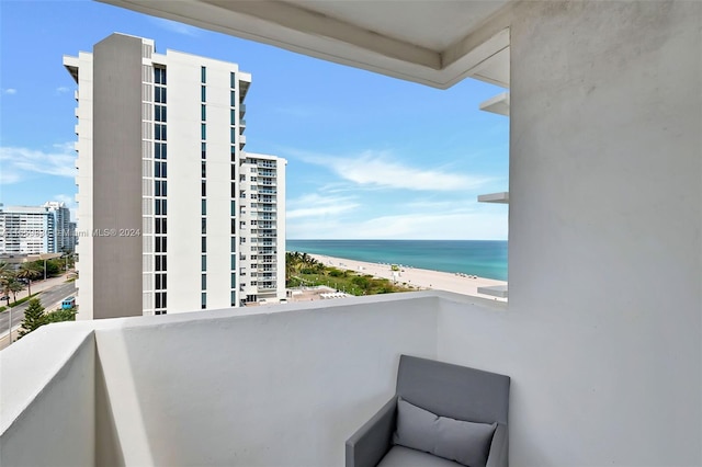 balcony featuring a view of the beach and a water view