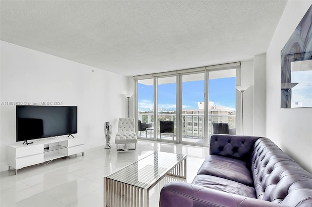 living room with a textured ceiling and a wall of windows