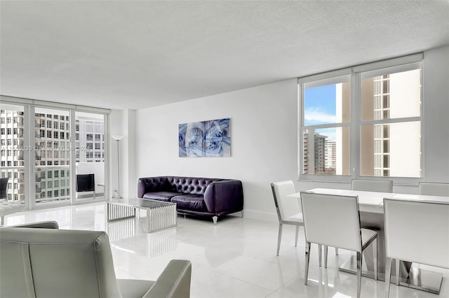 tiled living room with a textured ceiling and expansive windows