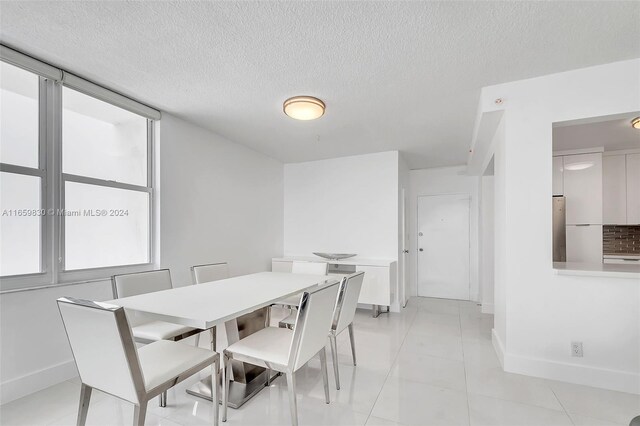 dining area featuring a textured ceiling and light tile patterned floors