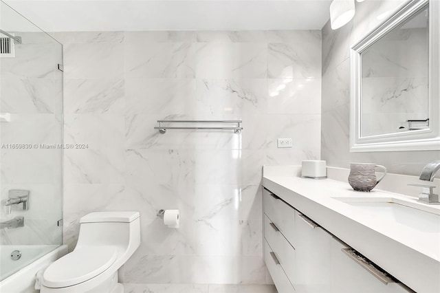 full bathroom featuring vanity, tile walls, tiled shower / bath combo, and toilet