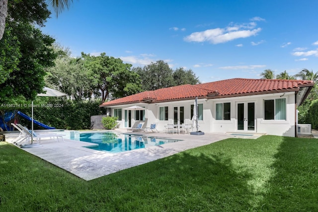 rear view of property featuring a patio, ac unit, french doors, and a yard