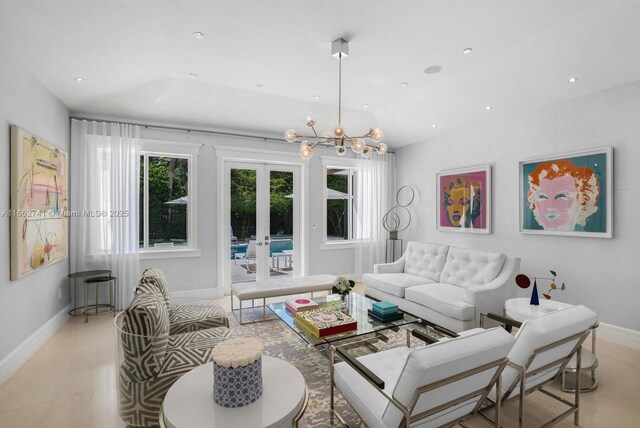 living room featuring french doors and a notable chandelier