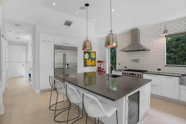 kitchen featuring beverage cooler, wall chimney exhaust hood, dark countertops, and high quality appliances