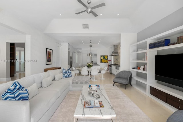 living room with ceiling fan and built in shelves