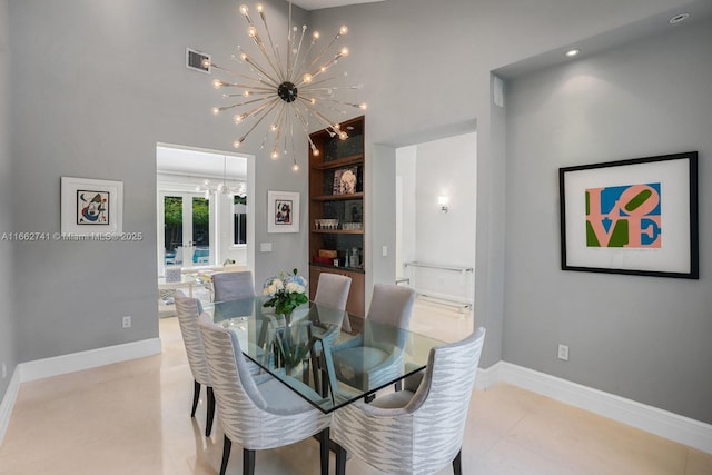 dining area with a chandelier, a towering ceiling, built in features, visible vents, and baseboards