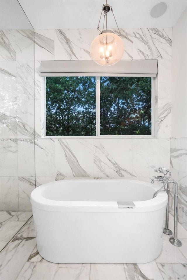 full bath with marble finish floor and a freestanding bath