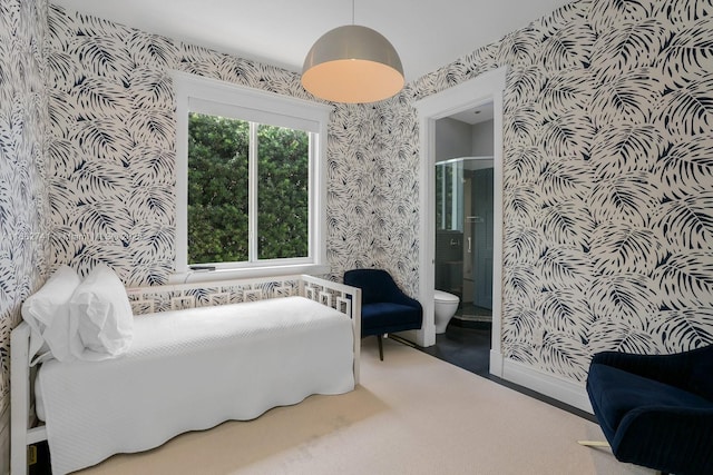 bedroom with wallpapered walls, baseboards, carpet flooring, and ensuite bathroom