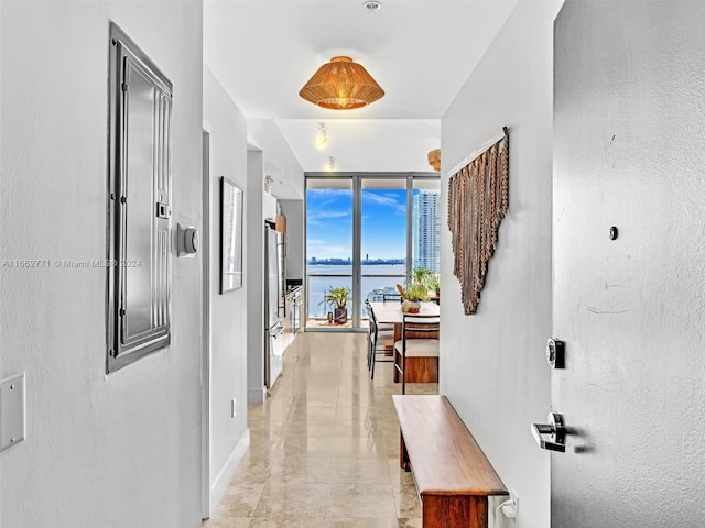 hallway with a water view and expansive windows