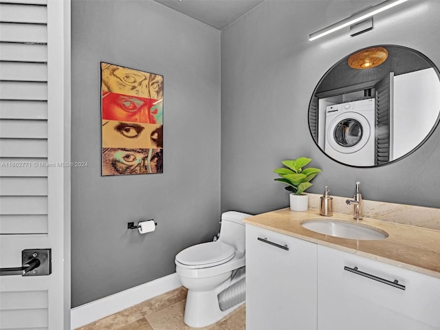 bathroom featuring washer / clothes dryer, vanity, toilet, and tile patterned floors