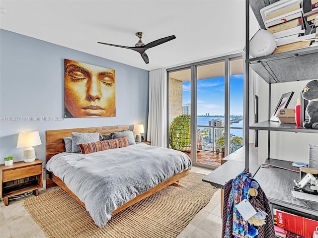 bedroom with a water view, floor to ceiling windows, light tile patterned floors, access to exterior, and ceiling fan