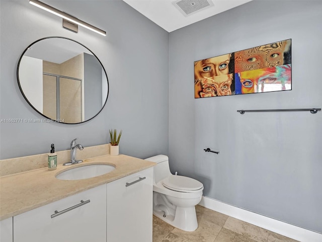 bathroom with vanity, a shower with shower door, toilet, and tile patterned floors