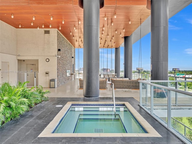 view of swimming pool featuring a community hot tub and a patio area