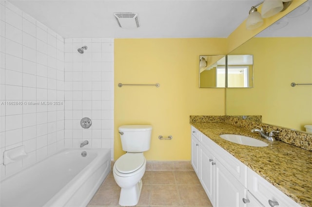 full bathroom with tiled shower / bath combo, tile patterned flooring, vanity, and toilet