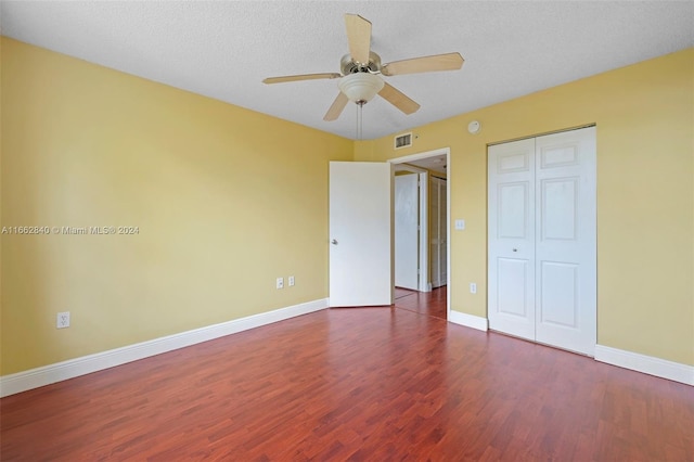 unfurnished bedroom featuring a closet, ceiling fan, hardwood / wood-style floors, and a textured ceiling